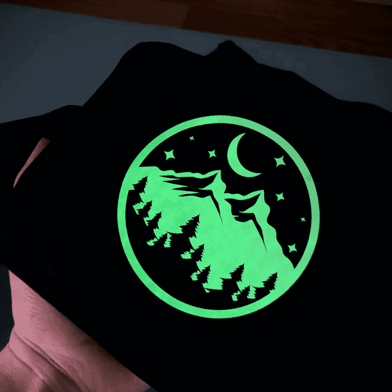 Motif montagne et lune en flex phosphorescent brillant vert dans le noir sur un t-shirt noir