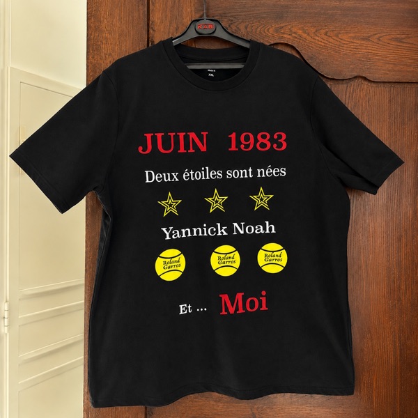 T-shirt noir « Juin 1983, deux étoiles sont nées : Yannick Noah et… moi » en flex rouge, blanc et jaune